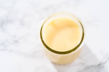 Küçük cam bir kavanozda beyaz çikolatalı ganache..