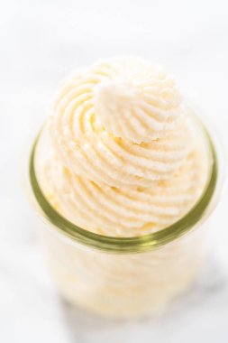 Küçük cam bir kavanozda beyaz çikolatalı ganache kreması..