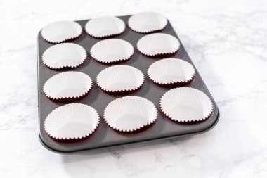 Kek tepsisini folyoyla kaplayıp beyaz çikolatalı ganache kremalı kırmızı kadife kekler pişirmek..