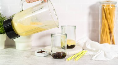 İçki bardaklarına mango boba smoothie dök..
