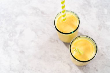 Taze yapılmış mango boba smoothie. Kağıt kamışla içme bardağında..