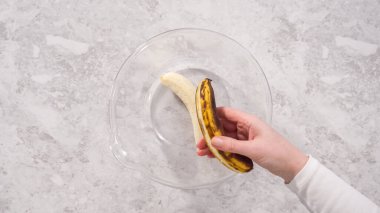 Düz yatıyordu. Adım adım. Hindistan cevizli muzlu krep hazırlamak için kırık muzları cam bir kasede kırıyorlar..