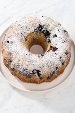 Taze fırınlanmış limonlu yaban mersinli kekin tozunu alıyorum..