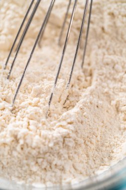 Kuru malzemeleri büyük bir bardakta çırpma kabıyla karıştırıp mini Paskalya ekmeği pişirmek..