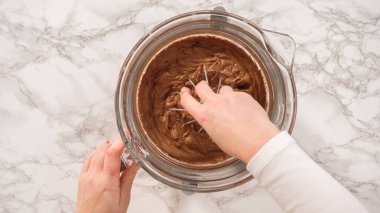 Düz yatıyordu. Adım adım. Elektrikli mutfak mikseriyle çikolatalı ganache çırpmak..