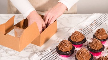 Adım adım. Çikolatalı kapkekleri çikolatalı ganache ile paketleyip kek kutusuna koymak..