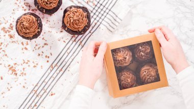 Düz yatıyordu. Adım adım. Çikolatalı kapkekleri çikolatalı ganache ile paketleyip kek kutusuna koymak..