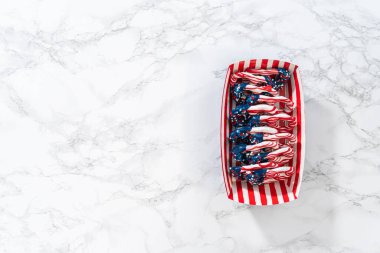 Flat lay. American flag. Red, white, and blue chocolate-covered pretzel twists.