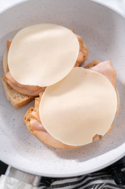 Prepare provolone and apple grilled cheese sandwich on a nonstick frying pan.