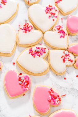 Sevgililer Günü için pembe ve beyaz kraliyet kremalı kalp şeklinde kurabiyeler..