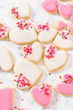 Sevgililer Günü için pembe ve beyaz kraliyet kremalı kalp şeklinde kurabiyeler..