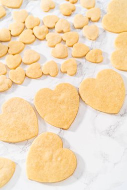 Sevgililer Günü için pembe ve beyaz kraliyet kremalı kalp şeklinde kurabiyeler..