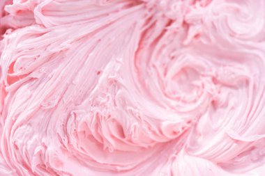 Manzarayı kapat. Vanilyalı kremanın içine pembe gıda boyası karıştırarak funfettti desenli pastayı süslemek için..