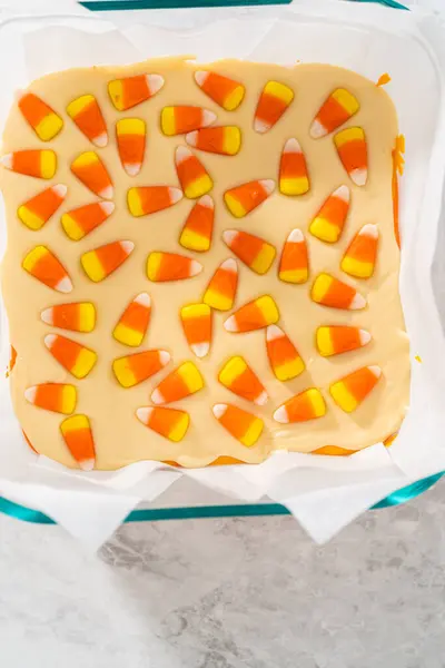 Removing Candy Corn Fudge Square Glass Baking Pan Lined Parchment — Stock Photo, Image