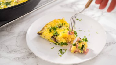 Adım adım. Fırından yeni çıkmış ıspanak ve jambonlu frittata dilimliyorum..