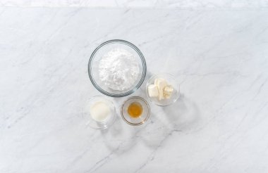 Düz yatıyordu. Krem peynir jölesi yapmak için cam karıştırma kabında ölçülmüş malzemeler..