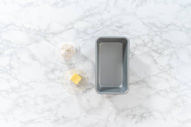 Düz yatıyordu. Kadehteki ölçülü malzemeler pişirmek için yağlanmış tavaya karıştırılıyor..