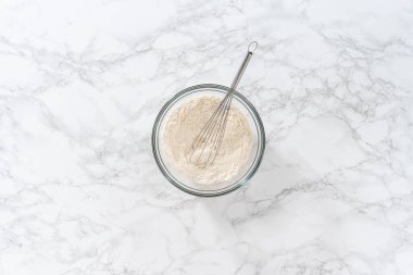 Beyaz çikolatalı limonlu kurabiye. Düz yatıyordu. Kuru malzemeyi büyük bir bardakta çırpma kabıyla karıştırıp limonlu kurabiyeleri beyaz çikolatayla karıştırıyorum..