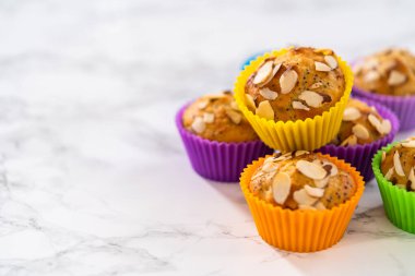 Mutfak tezgahında badem dilimleriyle süslenmiş taze pişmiş limonlu haşhaşlı çörekler..