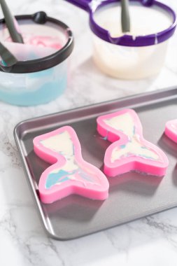 Silikon çikolata kalıplarını denizkızı kuyruğu ve deniz kabuğu şeklinde eritilmiş çikolatayla dolduruyorlar..