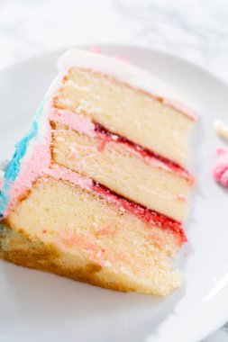 Deniz kızı temalı 3 katlı vanilyalı pasta dilimi. Çikolatalı deniz kızı kuyruğu ve beyaz tabakta deniz kabukları..