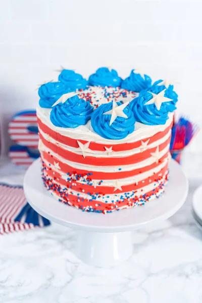 7月4日のお祝いのために白 青のバタークリームの霜降りでチョコレートケーキを飾る — ストック写真