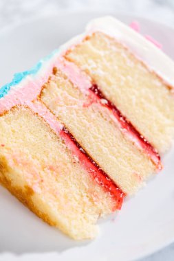 Deniz kızı temalı 3 katlı vanilyalı pasta dilimi. Çikolatalı deniz kızı kuyruğu ve beyaz tabakta deniz kabukları..