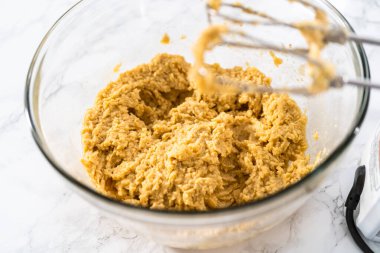 Mixing ingredients with a hand mixer to bake chocolate cookies with chocolate hearts for Valentines Day.