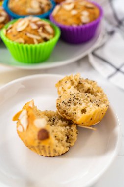 Mutfak tezgahında badem dilimleriyle süslenmiş taze pişmiş limonlu haşhaşlı çörekler..