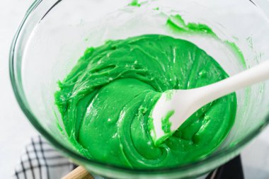 Çift kazanda çikolata parçacıkları ve diğer malzemeler eriyor. Kırmızı kalpli yeşil şekerleme hazırlamak için..