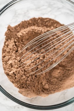 Büyük bir bardaktaki malzemeleri karıştırarak naneli çikolatalı kekler pişiriyorum..