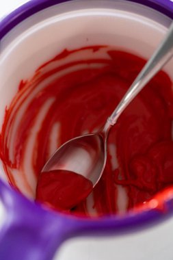 Kalp silikon çikolata kalıbını erimiş çikolatayla doldurup yeşil şekerleme yapmak için çikolata kalpler yapmak..