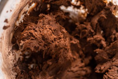 Mixing ingredients with a hand mixer to bake chocolate cookies with chocolate hearts for Valentines Day.