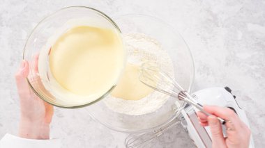 Düz yatıyordu. Adım adım. Fünyeli kek pişirmek için karıştırma kabındaki malzemeleri karıştırıyorum..