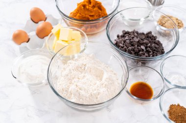 Çikolata kabaklı kek pişirmek için bardaktaki ölçülü malzemeler..