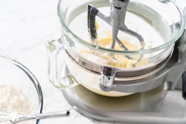 Mixing ingredients in kitchen electric mixer to bake American flag mini cupcakes.