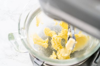 Mixing ingredients in kitchen electric mixer to bake American flag mini cupcakes.