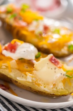 Fırında pişmiş patates. Tereyağı, ekşi krema, peynir ve pastırma parçalarıyla süslenmiş büyük fırında patates..
