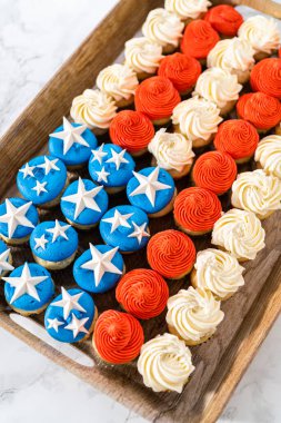 Arranging mini vanilla cupcakes in the shape of the American flag.