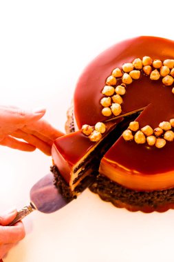 gurme çikolata, fındık ve beyaz zemin üzerine karamelli pasta.