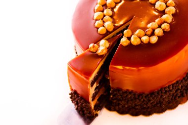 gurme çikolata, fındık ve beyaz zemin üzerine karamelli pasta.