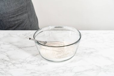 Kuru malzemelerle büyük bir bardakta çırpma kabını karıştırıp mini vanilyalı kekleri ombre pembe tereyağlı kremayla karıştırıyorum..