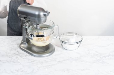 Mutfaktaki elektrikli mikserin içeriğini karıştırıp tereyağlı krema yapıyorum..