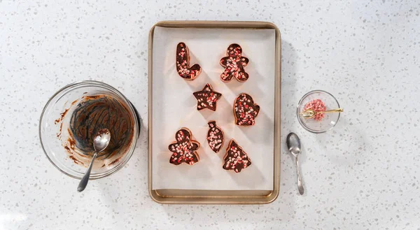 Flat lay. Filling cookie cutter with fudge mixture to prepare Christmas cookie-cutter peppermint fudge.