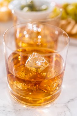 Buzlu viski, viski bardağında, beyaz mermer yüzeyde..