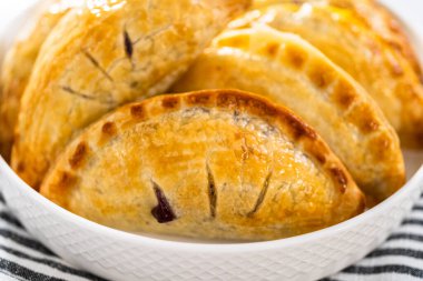 Mutfak tezgahında yaban mersinli taze pişmiş tatlı börekler..