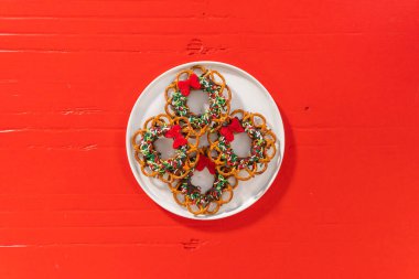 Flat lay. Chocolate pretzel Christmas wreath on a white plate.