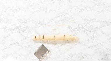 Düz yatıyordu. Tarçın ile doldurulmuş rulo ekmek hamuru ve daha küçük rulolara doğranmış fındıklar tarçınsız kek pişirmek için..