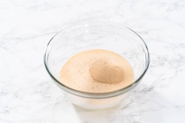 Mini Paskalya ekmeği pişirmek için bardaktaki kuru mayayı aktifleştiriyorum..