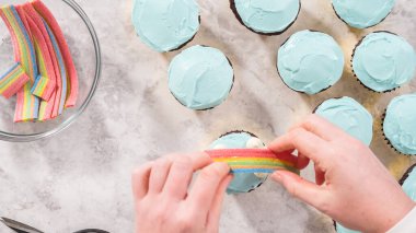 Düz yatıyordu. Adım adım. Çikolatalı kekleri tereyağlı krema ve gökkuşağı şekeriyle süslüyorum..